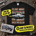 
Produktbillede af Personlig - Its not About miles per Gallon Its About Smiles Per Gallon - Med Din Bil MC Billede I illustrationstil T-Shirt