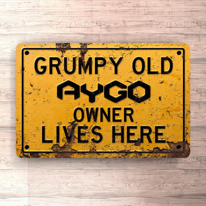 Toyota Aygo Grumpy Old Toyota Aygo Owner Lives Here Skilte, Musemåtte, Dørmåtte , Plakat-Skilte-Toyota-Garage Culture Shop- garage - man cave - merchandise