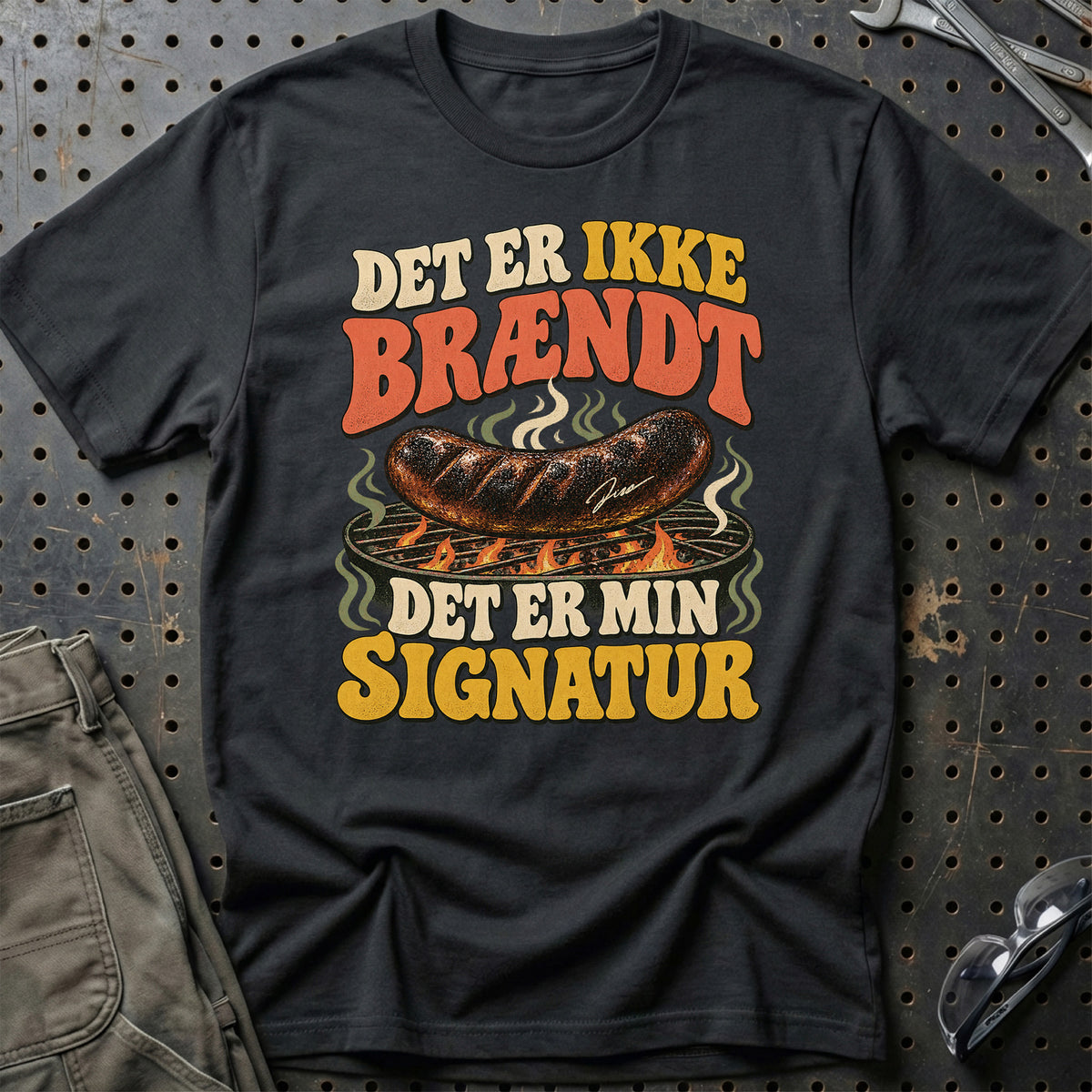 
Grillentusiast – Det er ikke brændt det er min signatur – Unisex T-Shirt med tryk foran, farve: Sort