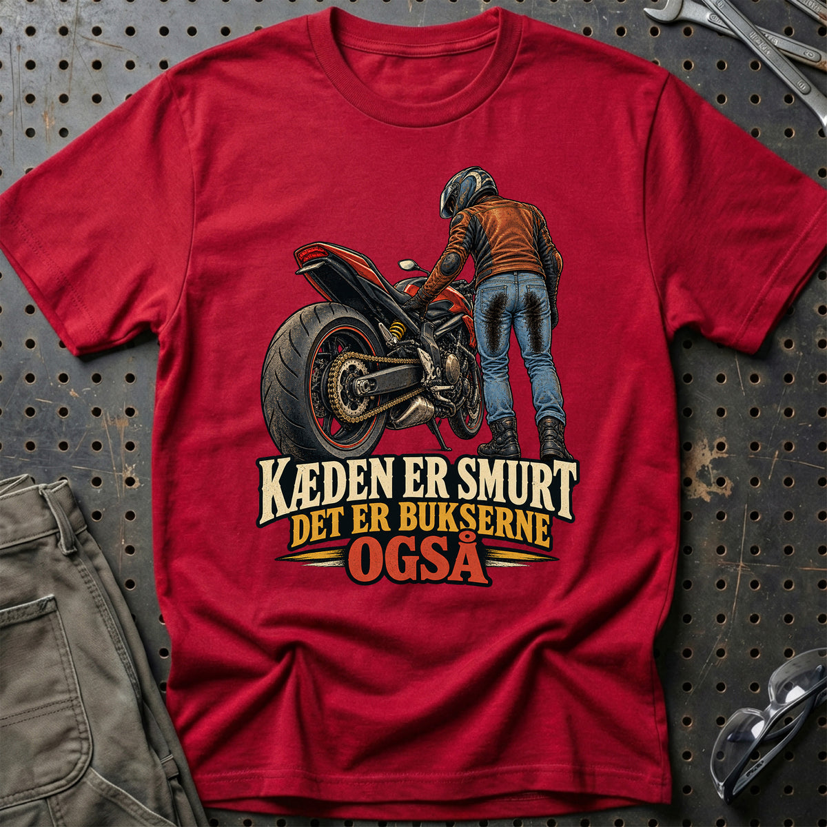 
Kæden er smurt det er bukserne også – Illustration – Unisex T-Shirt – Rød