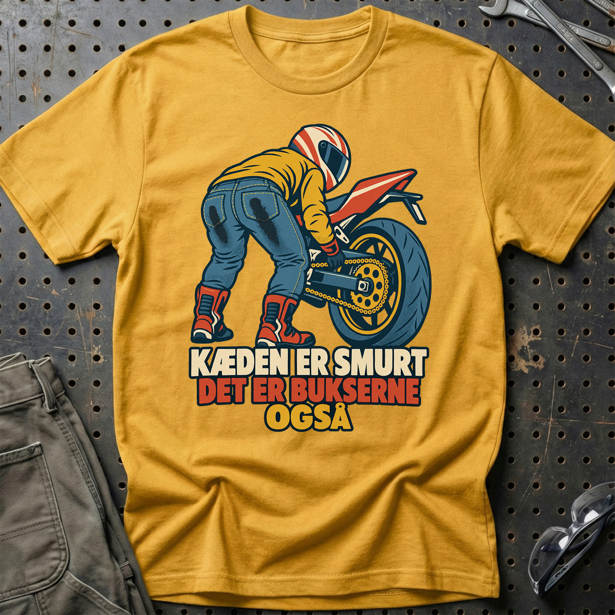 
Kæden er smurt det er bukserne også – Retro – Unisex T-Shirt – Guld