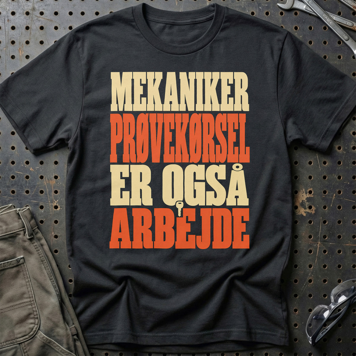 
Mekaniker – Prøvekørsel er også arbejde – Tekst – Unisex T-Shirt med tryk foran, farve: Sort